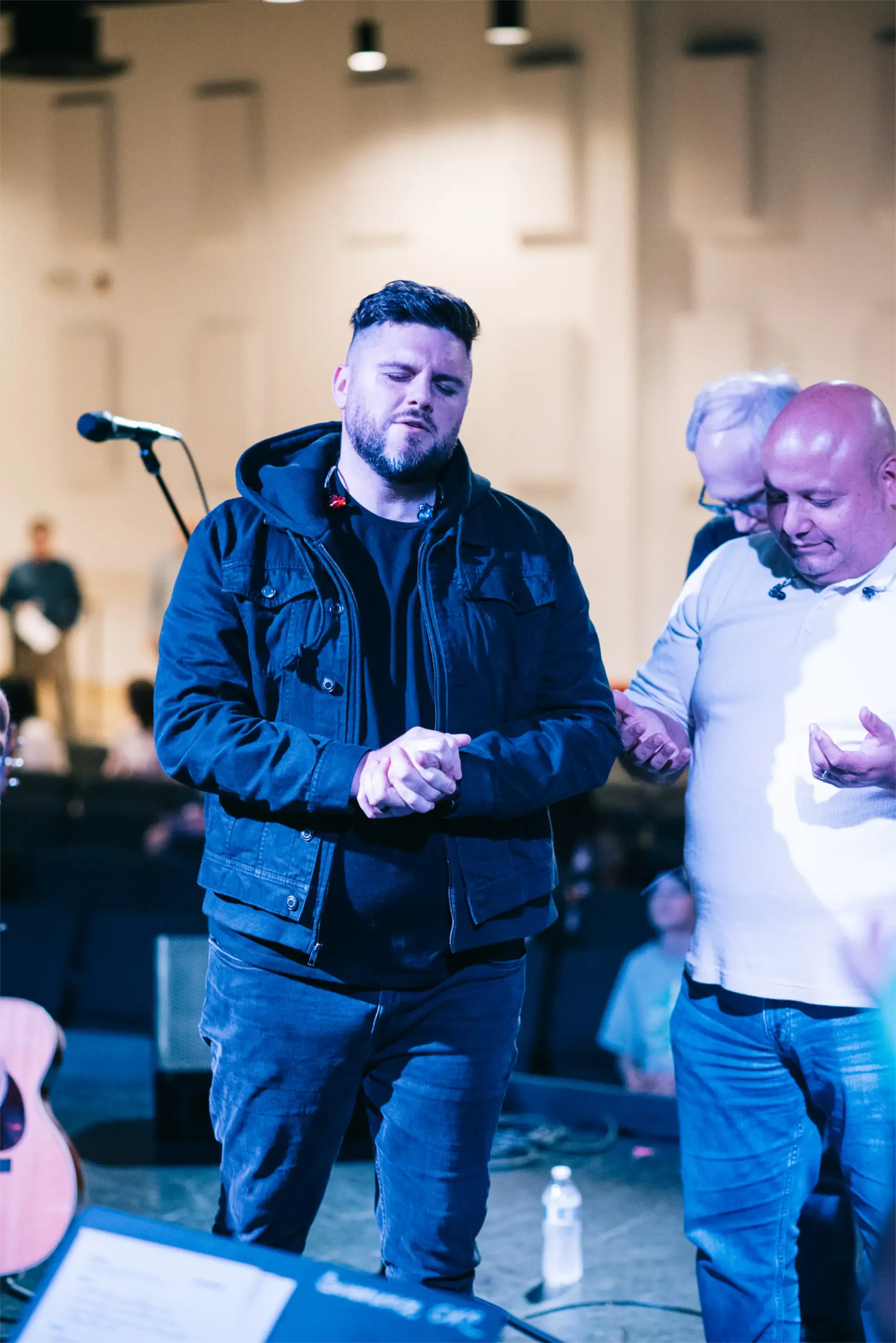 Men praying together during Convergence service